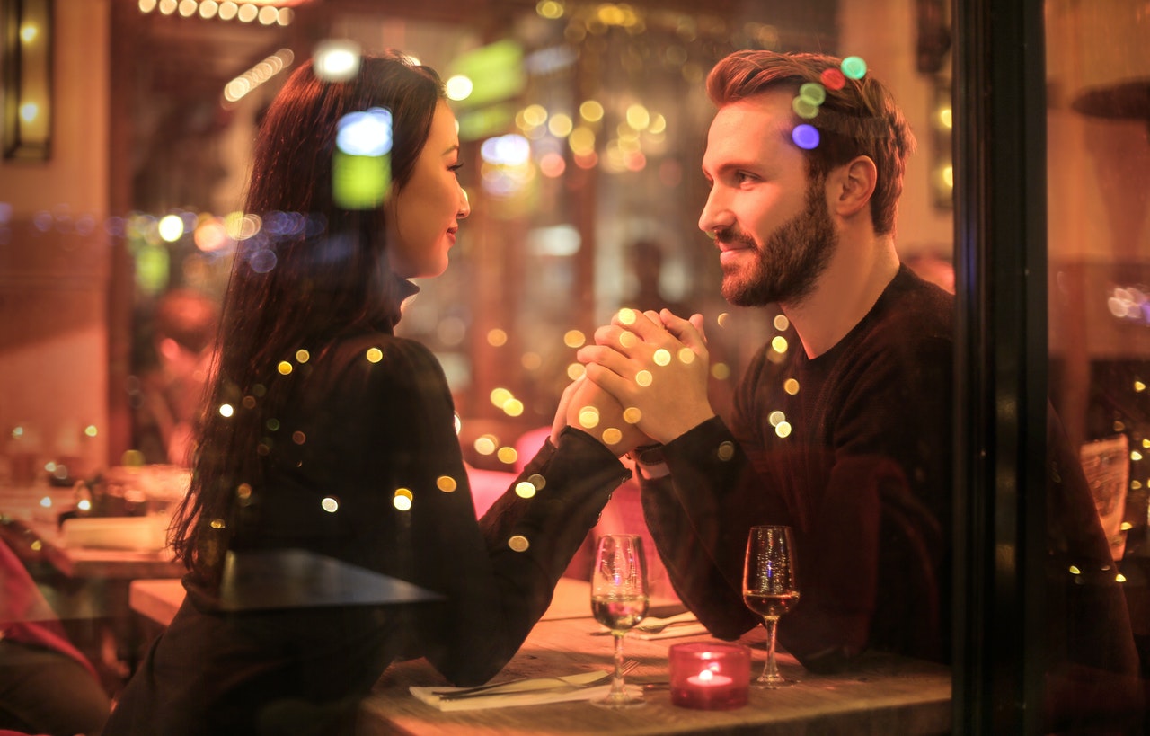 Kobieta w komfortowej stylizacji siedzi z mężczyzną na randce w restauracji