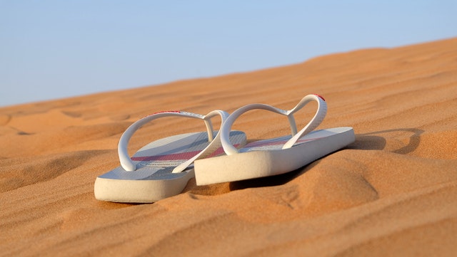 Gumowe klapki na lato leżą na piasku